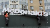 Workers remove the logo signage from a restaurant of McDonald's in Almaty, Kazakhstan, January 6, 2023. (REUTERS/Pavel Mikheyev)