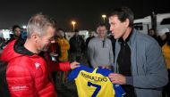 French rally driver Sebastien Loeb is presented with a Cristiano Ronaldo Al Nassr Jersey by the Saudi football club's French head coach Rudi Garcia at the bivouac in Saudi Arabia's capital Riyadh on January 8, 2023. (Photo by Franck Fife / AFP)