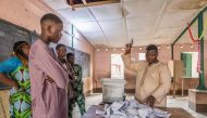 Members of the observers and the CENA (Commission Electorale Nationale Autonome) check the number of votes following the legislative elections at the public primary school, Charles Guillot de Zongo in Cotonou on January 8, 2023. (Photo by Yanick Folly / AFP)