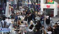 Street vendors (L) wait for customers at Myeongdong shopping district in Seoul, South Korea, January 9, 2023. REUTERS/Kim Hong-Ji

