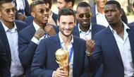 In this file photo taken on July 16, 2018 France's goalkeeper Hugo Lloris smiles and holds the trophy next to France's midfielder Paul Pogba (right) as they arrive for a reception at the Elysee Presidential Palace in Paris after French players won the Russia 2018 World Cup final football match.  (Photo by Lionel BONAVENTURE / AFP)