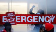 A hospital worker raises a fist as NYSNA nurses walk off the job, to go on strike at Mount Sinai Hospital in New York City, U.S. January 9, 2023. Reuters/Andrew Kelly
