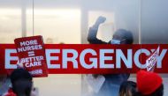 A hospital worker raises a fist as NYSNA nurses walk off the job, to go on strike at Mount Sinai Hospital in New York City, US, January 9, 2023. (REUTERS/Andrew Kelly)