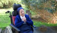 In this file photo taken on February 10, 2021 Sister Andre, Lucile Randon in the registry of birth, prays in a wheelchair, on the eve of her 117th birthday, in an EHPAD (Housing Establishment for Dependant Elderly People) in Toulon, southern France, where she has been living since 2009. (Photo by Nicolas Tucat / AFP)