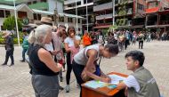Tourists queue to signup a petition to the railroad company to be evacuated on a 