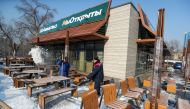 Employees remove snow outside a fast food restaurant, which used to operate under the McDonald's brand and reopened with no branding weeks after the U.S. company left the local market, in Almaty, Kazakhstan January 23, 2023. A sign reads: 