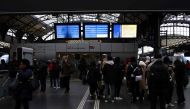 Passengers wait under screens displaying a traffic alert message during a total traffic shutdown at the Gare de l'Est train station in Paris on January 24, 2023. (Photo by Thomas Samson / AFP)