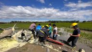 A handout photo from the Bureau of Fire Protection Region II taken and released on January 25, 2023, shows rescuers retrieving a body from a crashed plane in Pilar, Bataan, where two Philippine air force aviators were killed. (Photo by Handout / Bureau of Fire Protection Region II / AFP) 