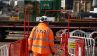 A worker walks along a walkway at the HS2 rail Curzon Street Station construction site in Birmingham, Britain, October 3, 2022. REUTERS/Phil Noble/File Photo