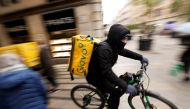 A Glovo delivery rider passes by a pedestrian area in Barcelona, Spain, January 24, 2023. REUTERS/Albert Gea/File Photo