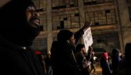 A demonstrator holds a placard as people march during a protest on the day of the release of a video showing police officers beating Tyre Nichols, the young Black man who died three days after he was pulled over while driving during a traffic stop by Memphis police officers, in downtown Memphis, Tennessee, U.S., January 27, 2023. REUTERS/Leah Millis
