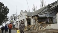 Local residents walk in front of a heavily damaged local administration building in the village of Lymany, Mykolaiv region on January 28, 2023, amid the Russian invasion of Ukraine. (Photo by Genya SAVILOV / AFP)