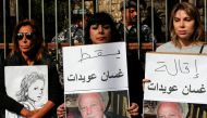 Lebanese demonstrators lift placards demanding top prosecutor Ghassan Oueidat be discharged and held accountable for the 2020 port blast, during a rally in the capital Beirut on January 28, 2023. - The judge leading the investigation into the deadly 2020 port explosion, charged on January 22 several powerful figures, including Oueidat, over the blast, reviving a probe that was suspended for over a year amid vehement political and legal pushback. (Photo by ANWAR AMRO / AFP)