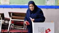 A Tunisian voter casts her ballot in the second round of parliamentary elections on January 29, 2023, in Ettadhamen, a working-class suburb west of the capital Tunis. (Photo by FETHI BELAID / AFP)