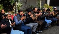 Relatives and police officials pray for a police officer Irfan Khan who was killed in a mosque suicide blast inside the police headquarters, during a condolence meeting at his residence in Peshawar on February 1, 2023. - A suicide blast at a mosque inside a Pakistan police headquarters was a targeted revenge attack, a police chief said, as rescue efforts ended with the death toll standing at 100. (Photo by Abdul MAJEED / AFP)