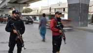 Policemen stand guard along a street in Peshawar on February 1, 2023, days after a mosque suicide blast inside a police headquarters. - A mosque blast that killed 101 people -- mostly police officers -- in northwest Pakistan this week has put a city long scarred by violence back on edge, residents said. (Photo by Farooq NAEEM / AFP)