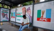 A man sits at a bus stop decorated with electoral campaign posters of All Progressives Congress (APC) Presidential candidate, Bola Tinubu, with his running mate Kashim Shettima, ahead of Nigeria's Presidential election, in Lagos, Nigeria January 31, 2023. REUTERS/Temilade Adelaja