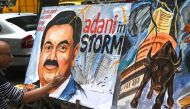 Art school teacher Sagar Kambli gives final touches to a painting of Indian businessman Gautam Adani highlighting the ongoing crisis of the Adani group in Mumbai on February 3, 2023. (Photo by INDRANIL MUKHERJEE / AFP)