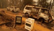 Burnt vehicles are seen at an area affected by a forest fire in Santa Juana, Concepcion province, Chile on February 5, 2023. (Photo by JAVIER TORRES / AFP)