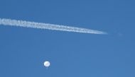 A jet flies by a suspected Chinese spy balloon as it floats off the coast in Surfside Beach, South Carolina, US on February 4, 2023. REUTERS/Randall Hill/File Photo
