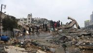 People gather around collapsed buildings as rescue teams look for survivors following an earthquake in the Syrian city of Aleppo on February 6, 2023. (Photo by AFP)
