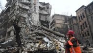 A member of a rescue team walks with his tools towards a collapsed building following an earthquake in Aleppo on February 6, 2023. Photo by AFP