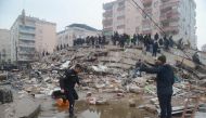 People search for survivors through the rubble in Diyarbakir, on February 6, 2023, after a 7.8-magnitude earthquake struck the country's south-east. - At least 284 people died in Turkey and more than 2,300 people were injured in one of Turkey's biggest quakes in at least a century, as search and rescue work continue in several major cities. (Photo by ILYAS AKENGIN / AFP)