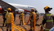 Firefighters prepare to load water into the US DC-10 Air Tanker at the Carriel Sur airport in Concepcion, Chile on February 6, 2023. - The forest fires that hit the south-central zone of Chile have already left 26 dead and have destroyed more than 1,100 homes, at a time when international aid begins to arrive to fight the flames.  (Photo by JAVIER TORRES / AFP)
 