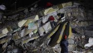 Rescuers search for victims and survivors amidst the rubble of collapsed buildings in Kahramanmaras, Turkey on February 7, 2023. (Photo by Adem Altan / AFP)
 