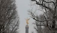 Berlin's landmark the Victory Column is seen behind snow-covered trees after snowfall on February 6, 2023 in the German capital. (Photo by Odd ANDERSEN / AFP)