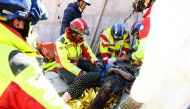 This photo taken and handed out on February 10, 2023 by the German relief organisation ISAR shows members of their rescue teams saving a woman from the rubble of a collapsed building in Kirikhan, Turkey, more than 100 hours after an earthquake hit Turkey and Syria.