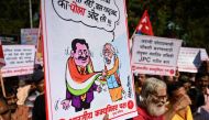 Communist Party of India (CPI) activists hold placards as they shout slogans against central government during a protest in Mumbai on February 13, 2023, calling for an enquiry into allegations of major accounting fraud at Adani, the country's biggest conglomerate. (Photo by Punit PARANJPE / AFP)