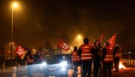 General Confederation of Labour (CGT) unionists participate to a slow-down operation against the pension reform, near Nantes' airport in Bouguenais, western France on February 16, 2023. (Photo by Sebastien SALOM-GOMIS / AFP)