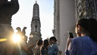  In this file photo taken on December 9, 2022 tourists take pictures at Wat Arun Buddhist temple in Bangkok. Photo by Lillian SUWANRUMPHA / AFP