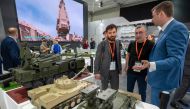 Visitors view mockups of ground vehicles as they tour the Russian pavilion during the International Defence Exhibtion (IDEX) at the Abu Dhabi International Exhibition Centre on February 20, 2023. (Photo by Ryan Lim / AFP)