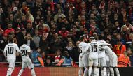 Real Madrid's French forward Karim Benzema is mobbed by teammates after scoring the team's fourth goal during the UEFA Champions League last 16 first leg football match between Liverpool and Real Madrid at Anfield in Liverpool, north west England on February 21, 2023. (Photo by Paul ELLIS / AFP)