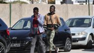 Sub-Saharan African men walk in the popular Ariana souk near Tunis on February 22, 2023. - A prominent rights group accused Tunisian President Kais Saied of 