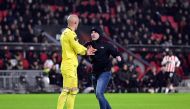 A pitch invader (R) attempts an assault on Sevilla FC goalkeeper Marko Dmitrovic (L) during the UEFA Europa league play-off match between PSV Eindhoven and Sevilla FC at the Phillips stadium in Eindhoven on February 23, 2023. (Photo by Olaf Kraak / ANP / AFP)