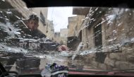 A Palestinian youth points at a bullet-riddled windshield outside a house that was targeted during an Israeli army raid in the Old City of Nablus. (Photo by Zain Jaafar / AFP)
 