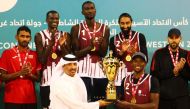 Ali Ghanem Al Kuwari, President of the Qatar and West Asia Volleyball Associations, presents the winner's trophy to Team Qatar's Ahmed Tijan.
