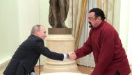 In this file photo taken on November 25, 2016 Russian President Vladimir Putin shakes hands with US action hero actor Steven Seagal after presenting a Russian passport to him during a meeting at the Kremlin in Moscow.  (Photo by Alexey DRUZHININ / SPUTNIK / AFP)
