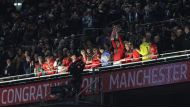 Manchester United's French defender Raphael Varane holds the trophy as Manchester United players celebrate their win after the English League Cup final football match between Manchester United and Newcastle United at Wembley Stadium, north-west London on February 26, 2023 (Photo by ADRIAN DENNIS / AFP)