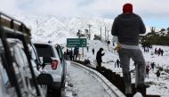 Cars are lined up after people parked on the side of the freeway to walk and play in the snow along Highway 14 in Los Angeles County on February 26, 2023 near Acton, California. Photo by MARIO TAMA / GETTY IMAGES NORTH AMERICA / Getty Images via AFP