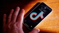 A picture taken on February 28, 2023 in Randers, Denmark shows a hand holding a smartphone with the TikTok app on the screen. - Denmark's parliament announced February 28, 2023 that it had asked MPs and all staff to remove the TikTok app from mobile devices because of the 