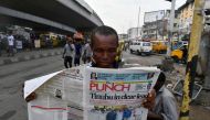A man reads newspaper at a newsstand as candidate of the ruling All Progressives Congress (APC) Bola Tinubu is declared President elect after the presidential election in Lagos, on March 1, 2023. (Photo by PIUS UTOMI EKPEI / AFP)