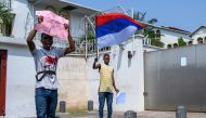 Protesters waving Russian flags gather in front of the French Embassy in Kinshasa on March 1, 2023 for a demonstration against the visit to the Democratic Republic of Congo of French President Emmanuel Macron. The DRC will this week be the last stage of a trip by Emmanuel Macron to Central Africa, which will also take him to Gabon for a summit on the forest, to Angola and to Congo-Brazzaville. - Brandishing Russian flags, a few dozen young Congolese demonstrated in Kinshasa on Wednesday against French President Emmanuel Macron's visit to the DRC, accusing him of supporting Rwanda at the expense of their country. (Photo by Arsene Mpiana / AFP)