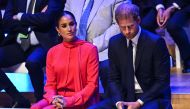 In this file photo taken on September 5, 2022 Britain's Meghan, Duchess of Sussex and Britain's Prince Harry, Duke of Sussex, react as they attend the annual One Young World Summit at Bridgewater Hall in Manchester, northwest England. (Photo by Oli SCARFF / AFP)