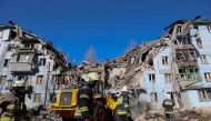 Ukrainian rescuers work on the five-storey residential building destroyed after a missile strike in Zaporizhzhia on March 2, 2023, amid the Russian invasion of Ukraine. (Photo by Katerina Klochko / AFP)