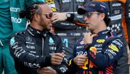 Mercedes' British driver Lewis Hamilton (left) speaks with Red Bull Racing's Mexican driver Sergio Perez during a group photo opportunity with other racers ahead of the Bahrain Formula One Grand Prix at the Bahrain International Circuit in Sakhir on March 5, 2023. (Photo by Giuseppe CACACE / AFP)