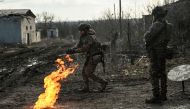 Ukrainian servicemen light a fire with gun powder to get warm near the city of Bakhmut in the region of Donbas on March 5, 2023, amid the Russian invasion of Ukraine. (Photo by Aris Messinis / AFP)